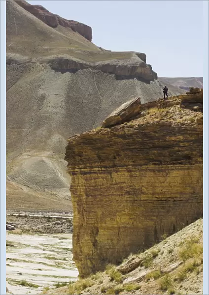 Tourist standing on rock cliff looking at Band-I-Zulfiqar the main lake