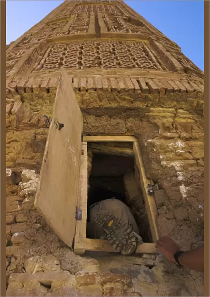 Tourist climbing into the minaret by a window, 12th Century Minaret of Jam