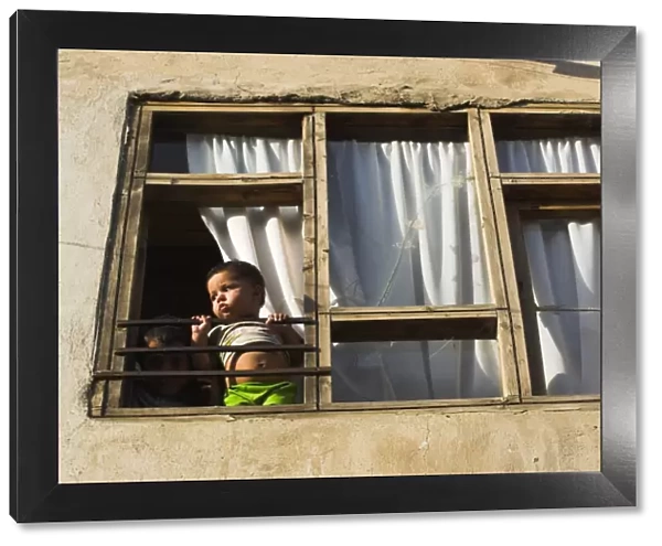 Children looking out of window of old house, Old City, Kabul, Afghanistan, Asia