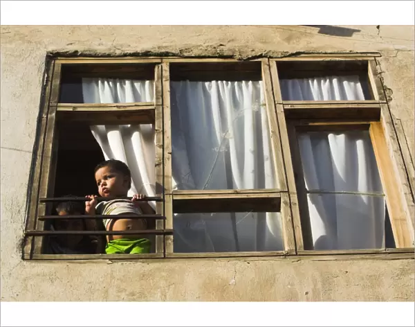 Children looking out of window of old house, Old City, Kabul, Afghanistan, Asia
