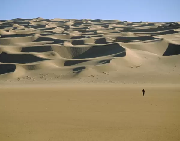 Sahara Desert with lone figure in foreground, Amguid, Algeria, Africa