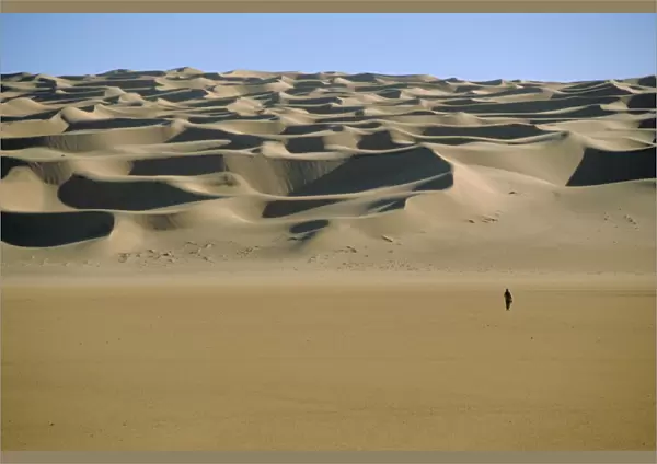 Sahara Desert with lone figure in foreground, Amguid, Algeria, Africa