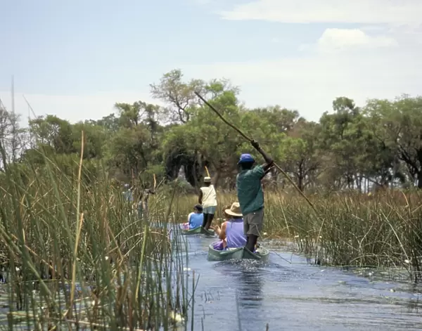 Tourists in dug out canoe (mokoro), Okavango Delta, Botswana, Africa