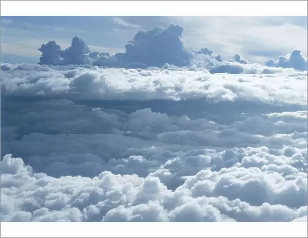 Aerial of banks of puffy white clouds seen from the air