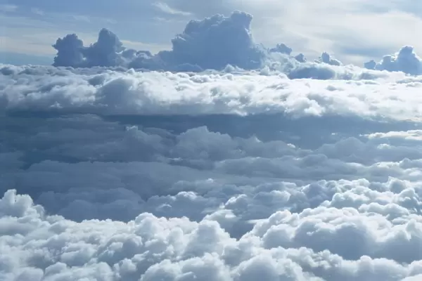 Aerial of banks of puffy white clouds seen from the air