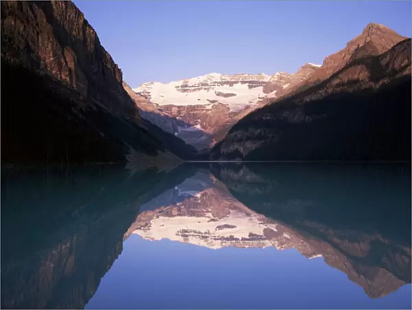View to Mount Victoria across the still waters of Lake Louise, at sunrise
