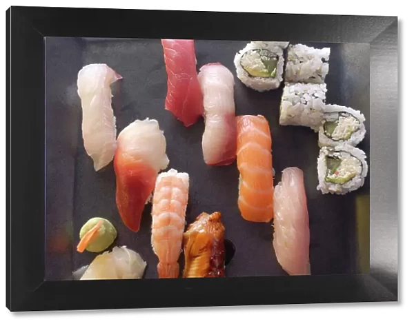 Plate of sushi covered with raw fish and stuffed