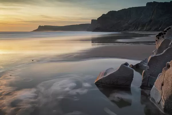 Sunset over a deserted Mewslade Bay in Gower in winter, South Wales, United Kingdom