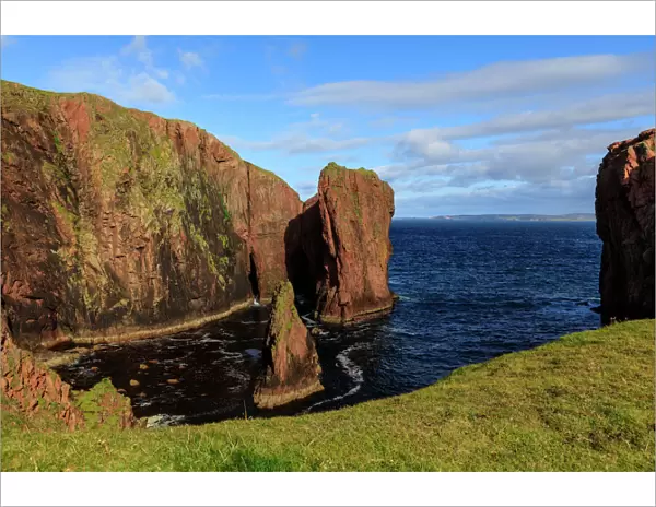 North Ham, lichen covered huge red granite cliffs and stacks, Muckle Roe Island, Shetland