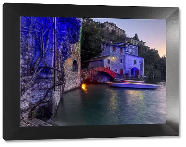Boat in motion under the illuminated Nesso bridge, Lake Como, Lombardy, Italian Lakes