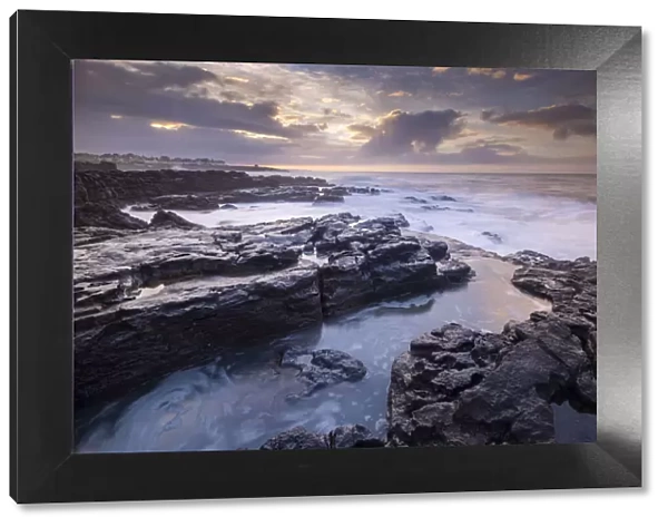 Sunrise over the dramatic rocky coastline of Porthcawl in winter, South Wales