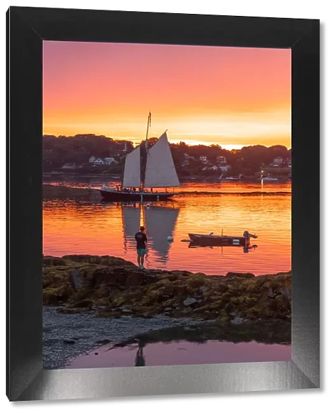 A schooner returns to dock at sunset at Bailey Island, Casco Bay, Maine