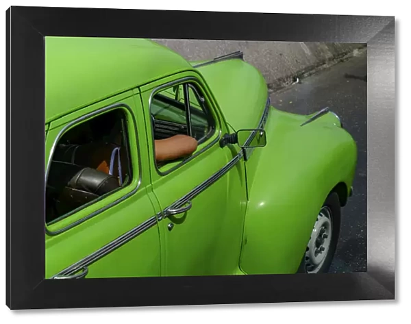 Lime green vintage car with passengers arm through window, Havana, Cuba, West Indies