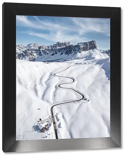 Aerial view of winding mountain road in the snow and Lastoi De Formin, Giau Pass