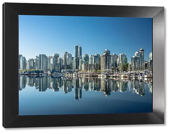 Skyline of Vancouver, with perfect reflection of skyscrapers in the blue waters of Stanley Park, Vancouver, British Columbia, Canada, North America