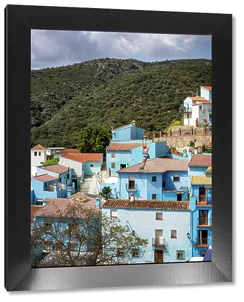 Person doing slide (zip line) in blue painted Smurf village of Juzcar, Pueblos Blancos region, Andalusia, Spain, Europe