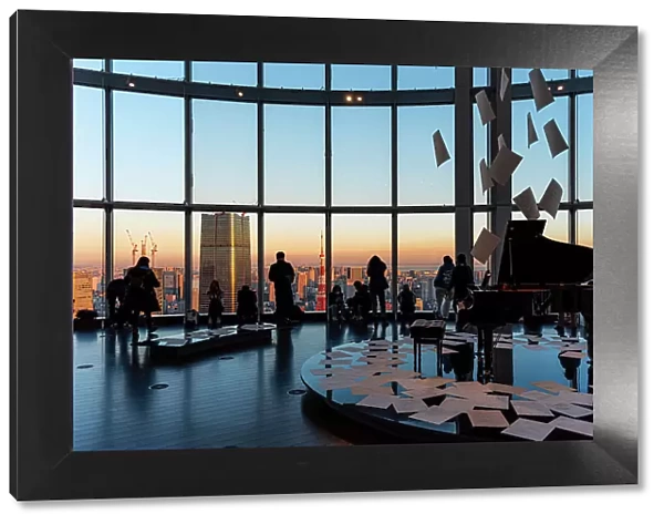 Panoramic view through a big window in Roppongi Hills, with visitors enjoying the evening light, silhouettes and grand piano, Tokyo, Honshu, Japan, Asia