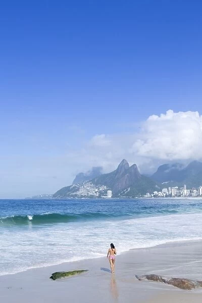 A 20-25 year old young Brazilian woman on Ipanema Beach with the Morro Dois Irmaos
