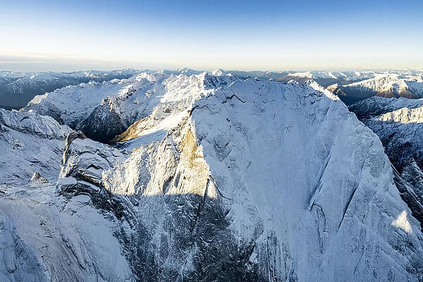 Aerial vew of majestic rocks of the snowcapped Pizzo Badile in winter, Val Bregaglia