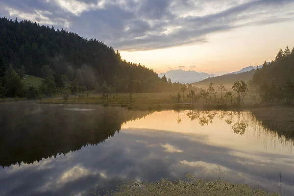 Aerial view of the misty sunrise over swamp of Pian di Gembro Nature Reserve, Aprica