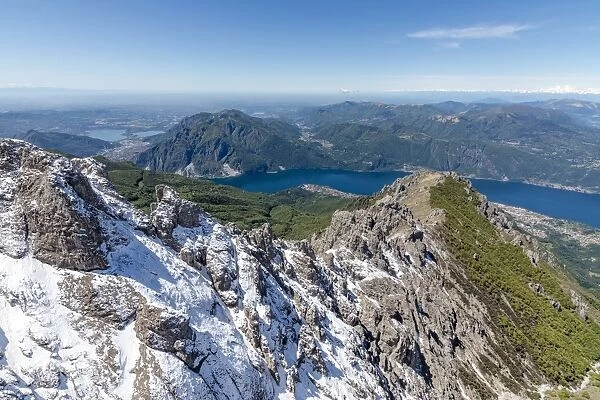 Aerial view of the snowy ridges of the Grignetta mountain with Lake Como in the background