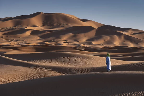 A Berber man in traditional dress in the Sand Dunes of Erg Chebbi, Sahara Desert, Morocco