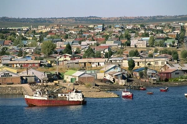 Boats on the waterfront and the town of Puerto Natales, in Magallanes, Chile