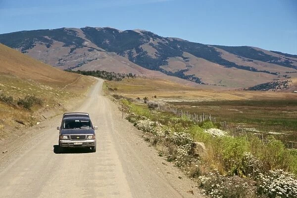 Car driving on a dirt road in Patagonia, Chile, South America