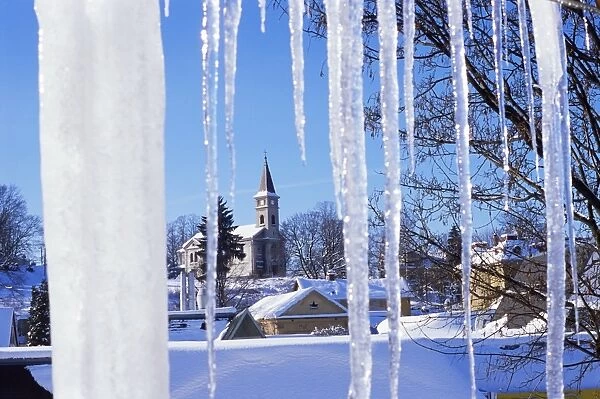 Catholic church in village of Luceny nad Nisou, Jizerske mountains, seen through icicles