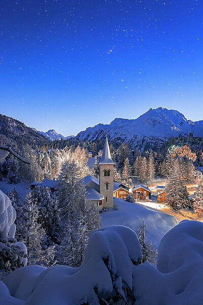Chiesa Bianca covered with snow under a bright starry night sky at Christmas, Maloja, Bregaglia, Engadine, Canton of Graubunden, Switzerland, Europe