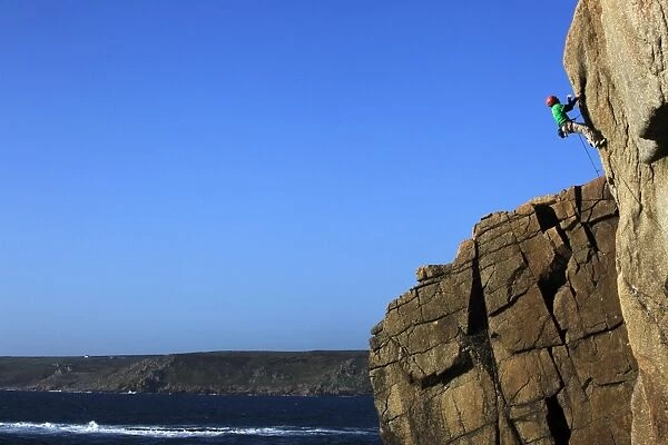 A climber tackles a difficult route on the cliffs near Sennen Cove, a popular rock climbing area at Lands End, Cornwall, England, United
