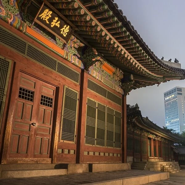 Deoksugung Palace, traditional Korean building, illuminated at dusk, with modern
