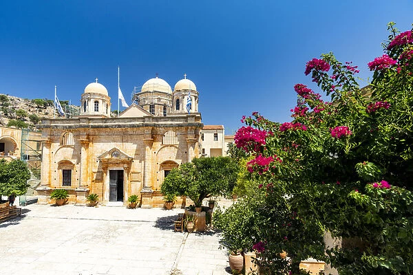 Facade of the old monastery of Agia Triada of Tzagarolon surrounded by bougainvillea in summer, Crete island, Greek Islands, Greece, Europe