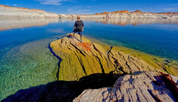 A hiker standing on a rock peninsula at Lake Powell, Arizona, United States of America