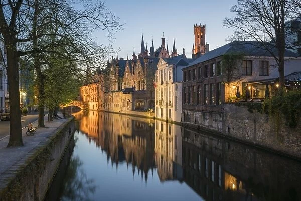 Houses and bridge reflected in the Groenerei canal at dusk, Bruges, West Flanders province