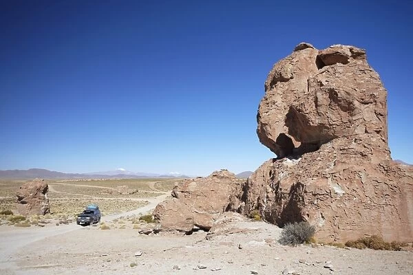 Jeep driving through rocky landscape on the Altiplano, Potosi Department, Bolivia, South America