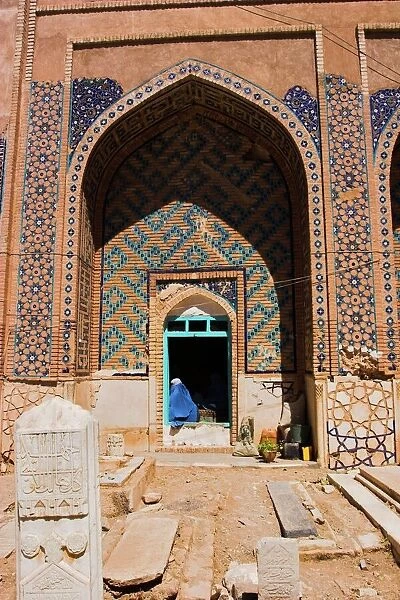 Lady pilgrim in blue burqa sitting in doorway at Sufi shrine of Gazargah