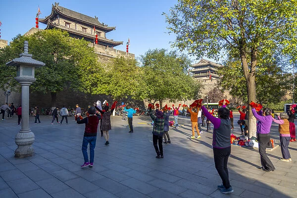 Locals performing Tai chi near City wall of Xi an, Shaanxi Province, People s