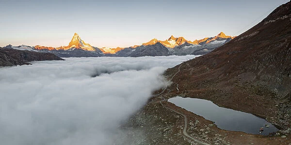 Matterhorn, Dent Blanche, Wellenkuppe and Zinalrothorn peaks in fog from Stellisee lake