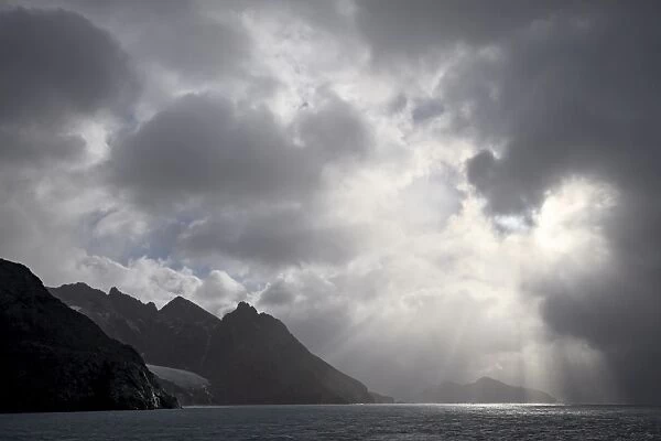 Mountainous coastline near Drygalski Fjord with cloudy skies