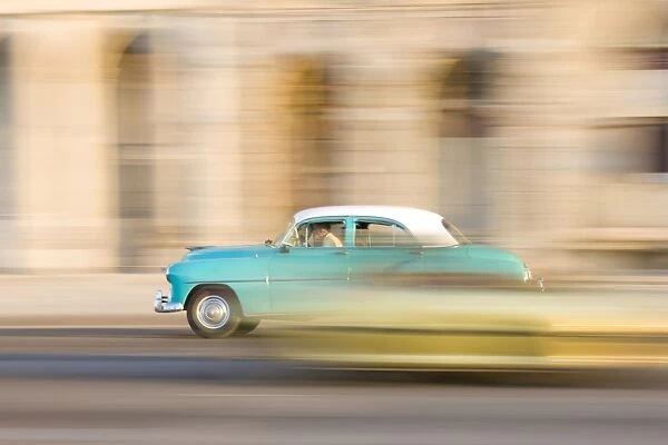 Panned shot of a classic American car on The Malecon, Havana, Cuba, West Indies