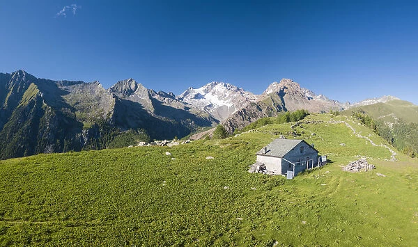 Panoramic aerial view of hut on green meadows, Scermendone Alp, Sondrio province