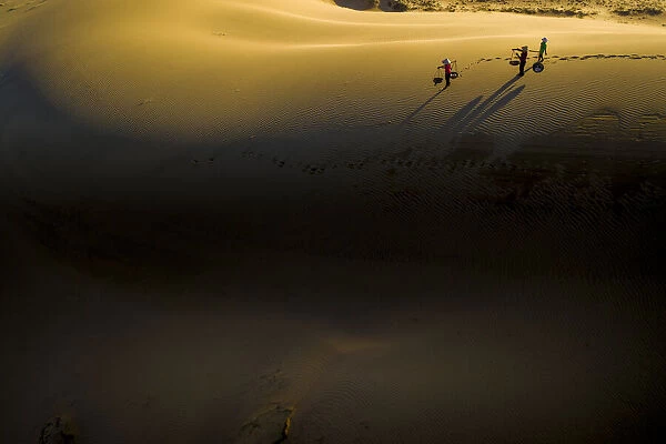 People walking home across Nam Cuong sand dunes, Ninh Thuan, Vietnam, Indochina