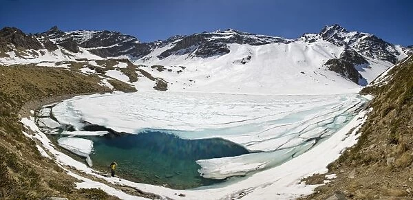 Photographer at Laj dal Teo where snow begins to melt due to spring thaw, Poschiavo Valley