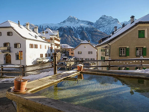 A plaza and fountain in the Alpine village of Sent in winter, Sent, Switzerland, Europe
