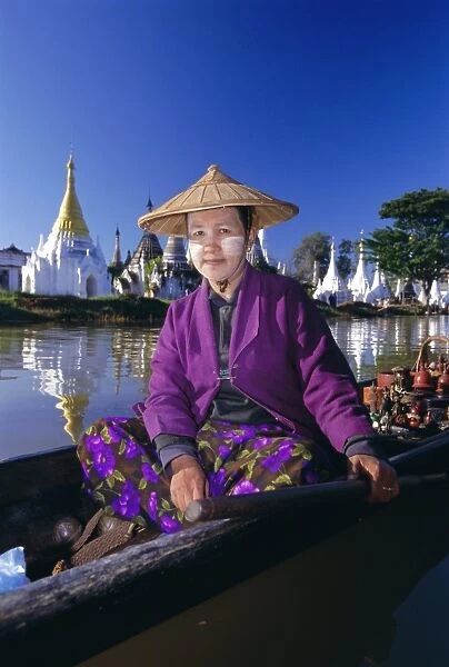 Portrait of a woman in a boat, wearing a straw hat and face paste, Phaung Daw U Kyaung