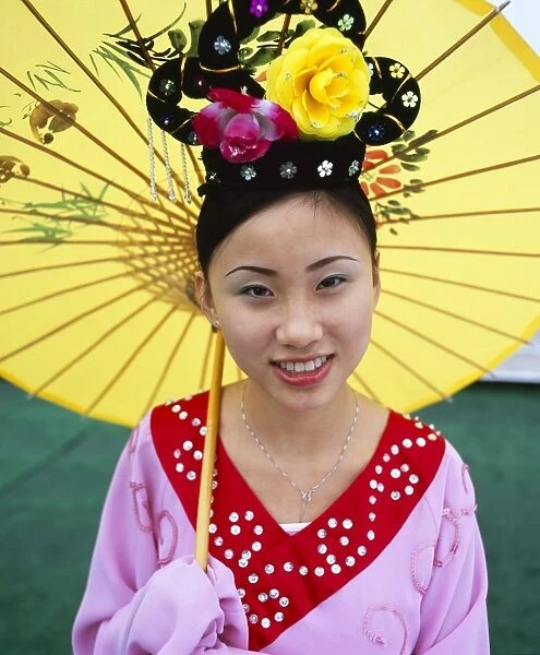Portrait of a young woman holding parasol, smiling