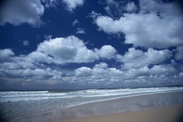 Puffy white clouds in blue skies over the coast of Portugal
