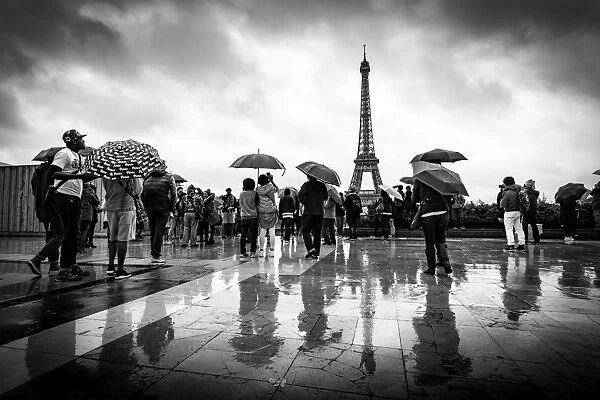 Reflections of tourists in the rain at the Palais De Chaillot looking out towards the Eiffel Tower