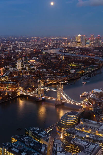River Thames, Tower Bridge and Canary Wharf from above at dusk with moon, London, England